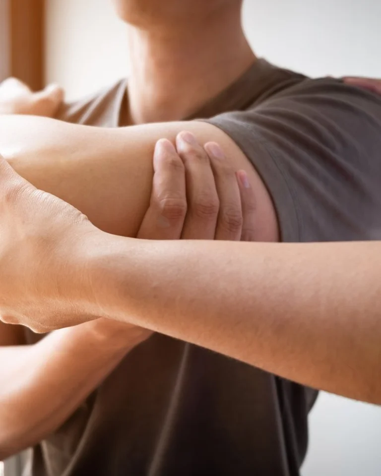 Osteopaat begeleidt een patiënt in een rustige behandelruimte